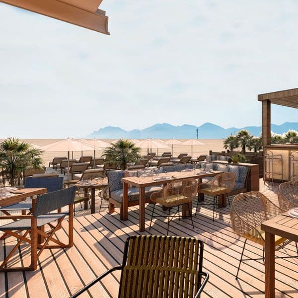 Tables et chaises du restaurant de la plage, avec la mer en arrière plan